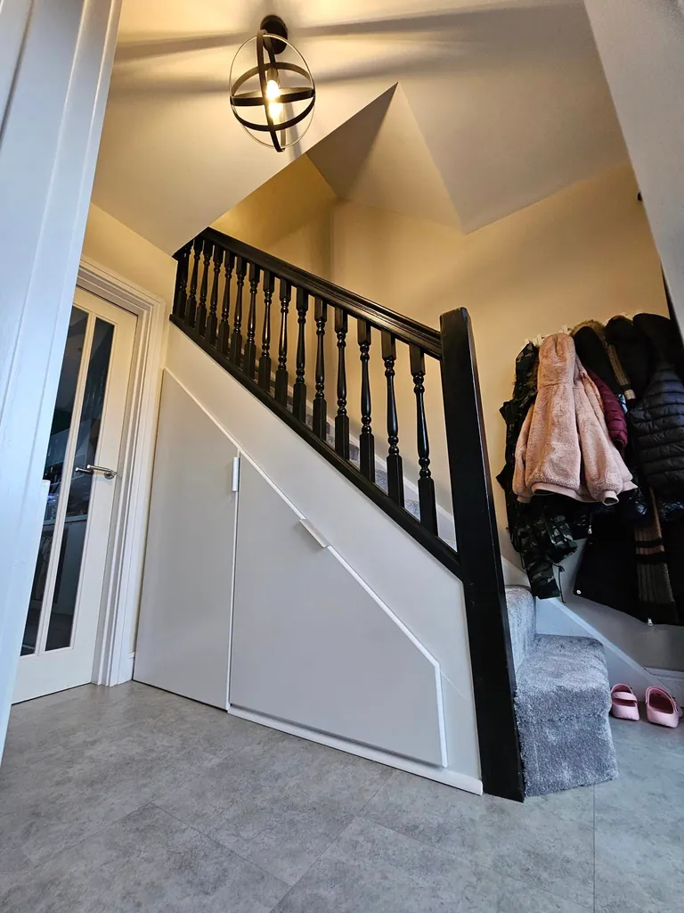 Painted staircase with dark handrail and spindles