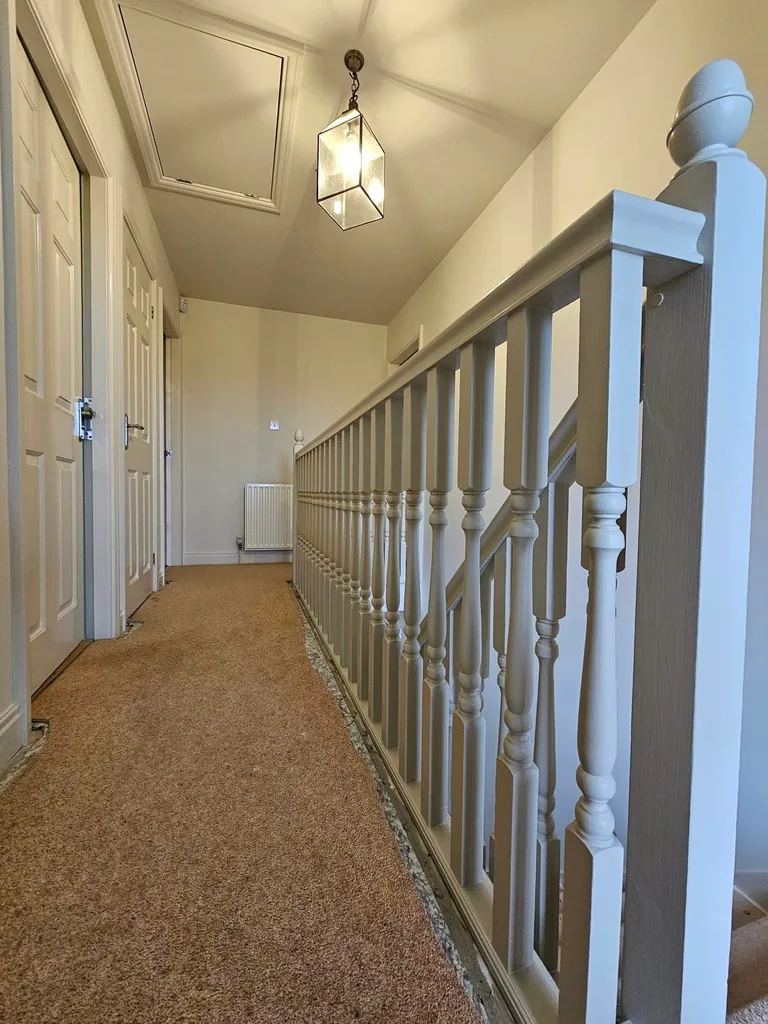Decorated landing with pale walls and painted staircase spindles