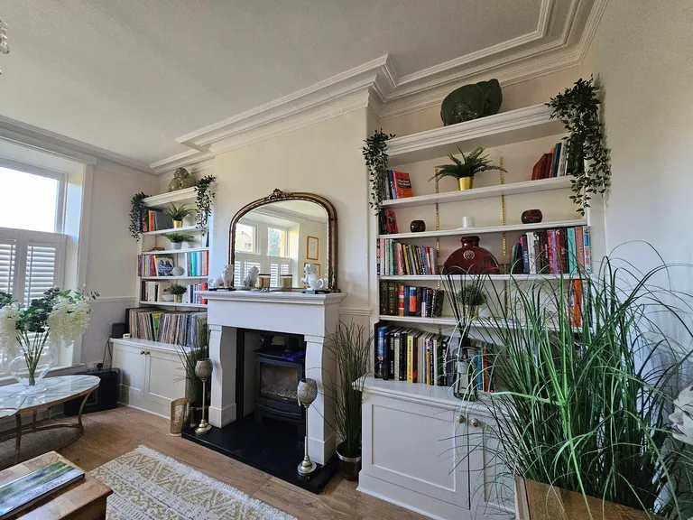 White-painted built-in shelves and fireplace surround in a living room